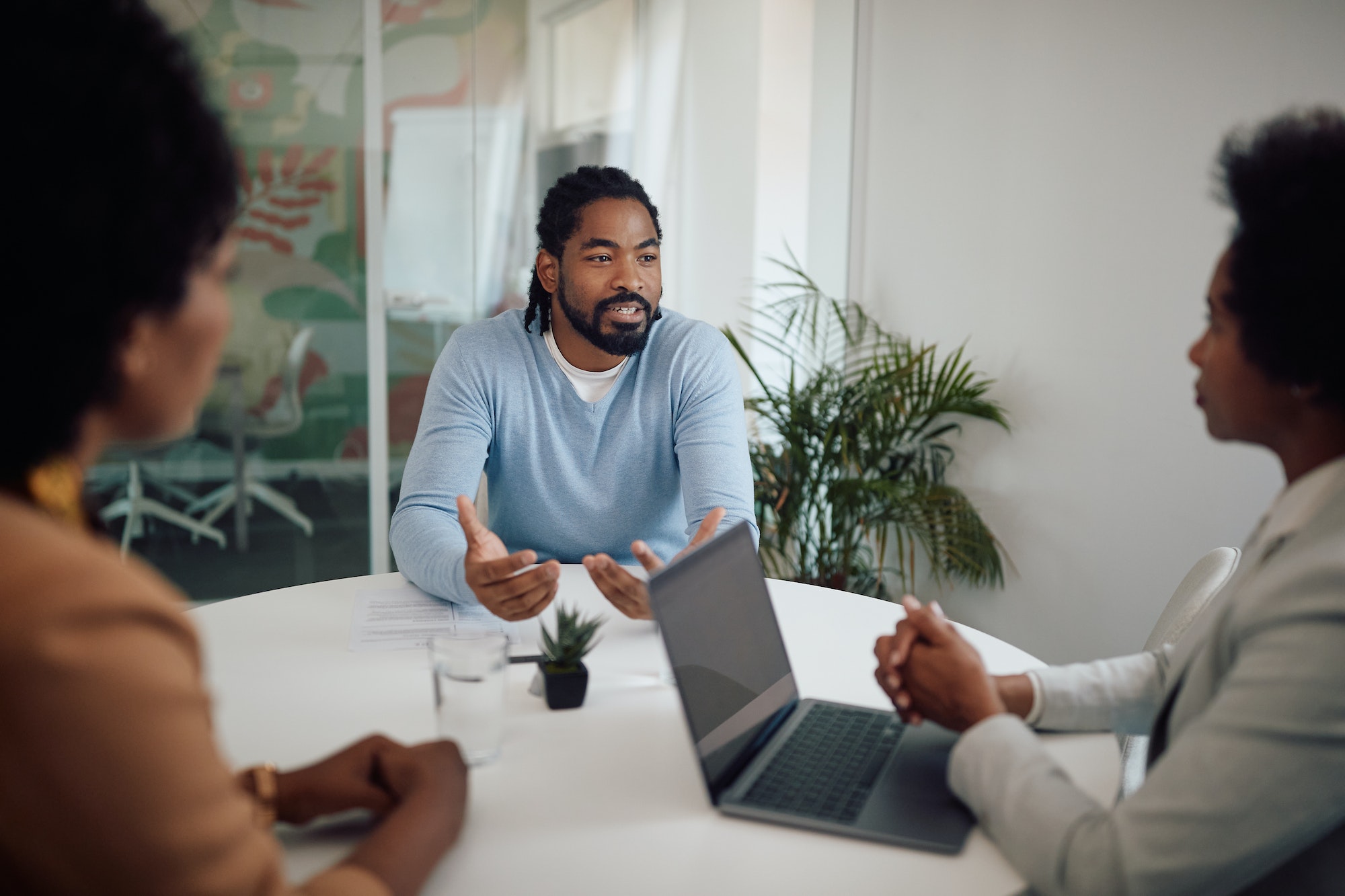 Young black man talking to human resource team during job interview in the office.